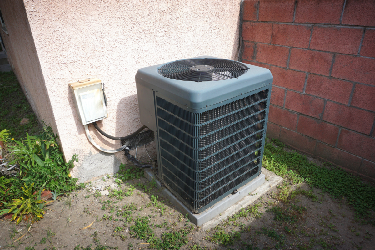 Outdoor AC unit cleaning starts with making sure the area is clear of debris and not overgrown.