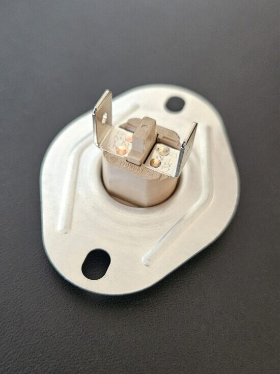 The back side of a furnace limit switch, showing the reset button between the two prongs.