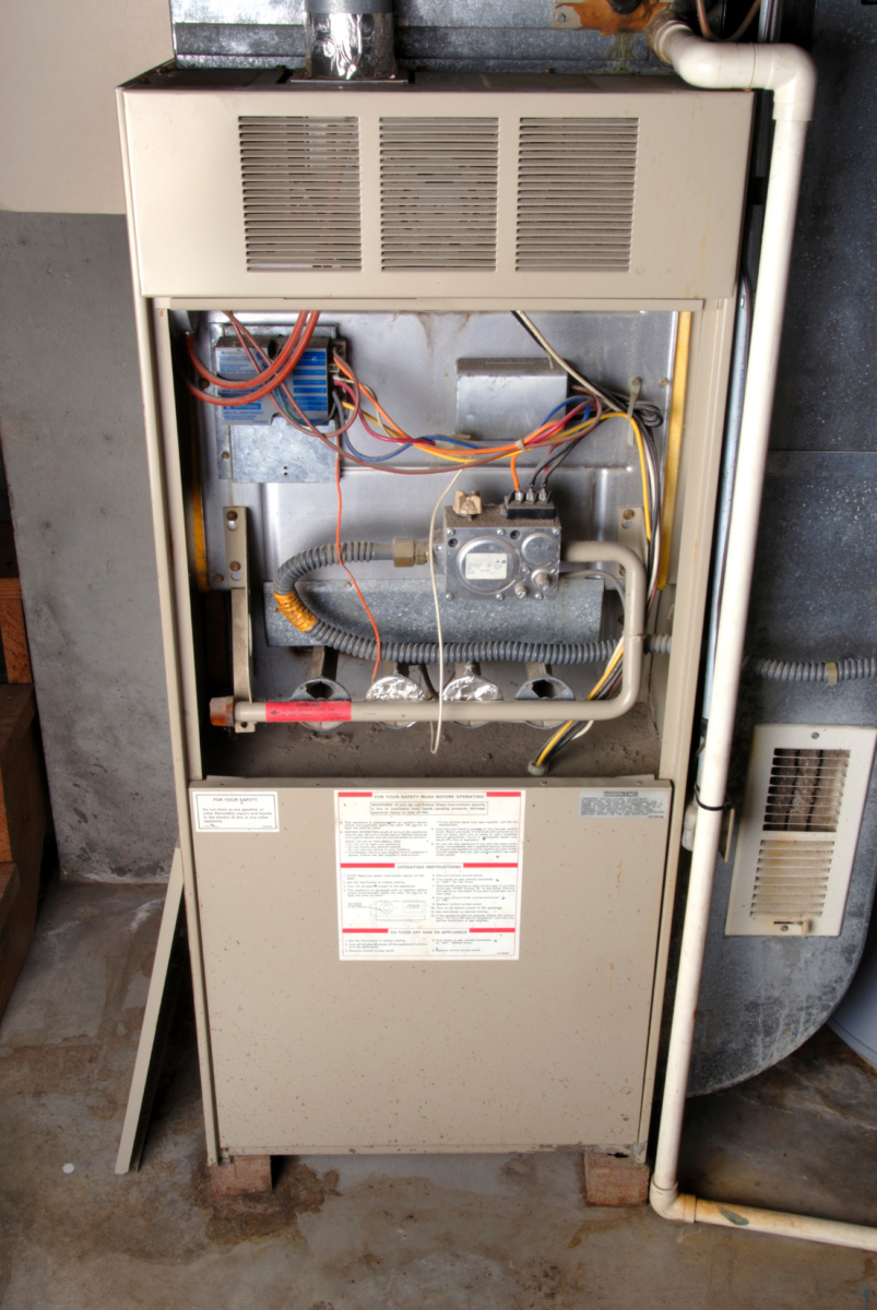 An older furnace with the upper front cover removed.
