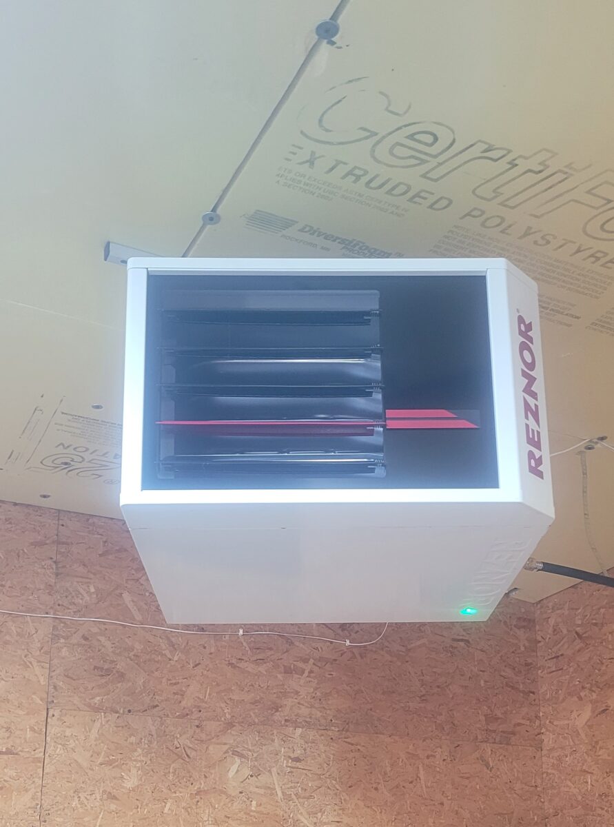 Reznor garage heater installed in an unfinished garage used as a workshop.